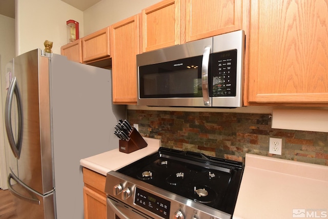 kitchen with light countertops, stainless steel appliances, decorative backsplash, and light brown cabinetry