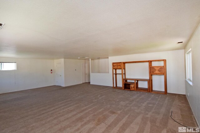 empty room with a textured ceiling and carpet