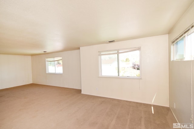 unfurnished room with light carpet and visible vents