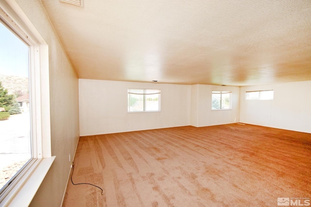 carpeted spare room featuring a textured ceiling