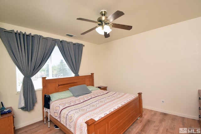 bedroom featuring light wood-type flooring, baseboards, visible vents, and ceiling fan