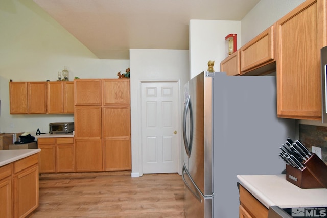 kitchen with light countertops, light wood finished floors, and freestanding refrigerator