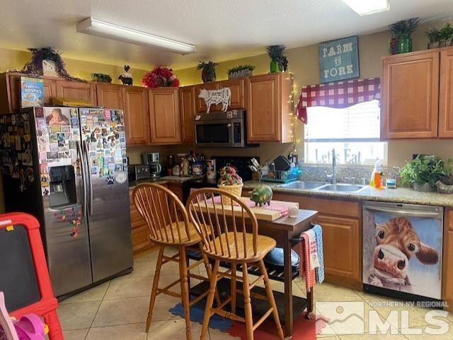 kitchen featuring light tile patterned flooring, stainless steel appliances, and sink