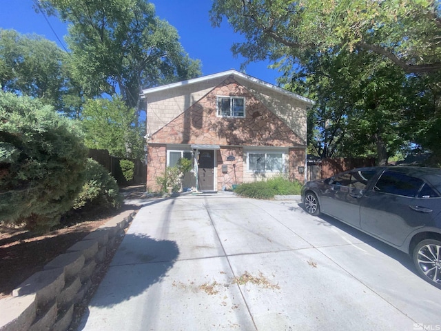 view of front of property with stone siding and fence