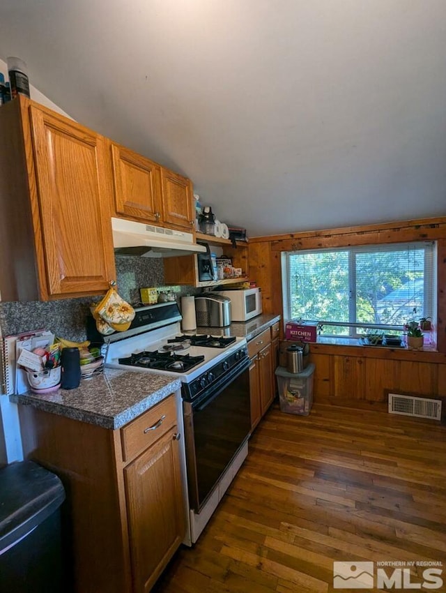 kitchen with dark wood-style floors, white appliances, brown cabinets, and under cabinet range hood