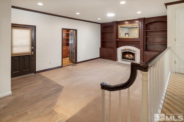 unfurnished living room featuring ornamental molding and light hardwood / wood-style flooring