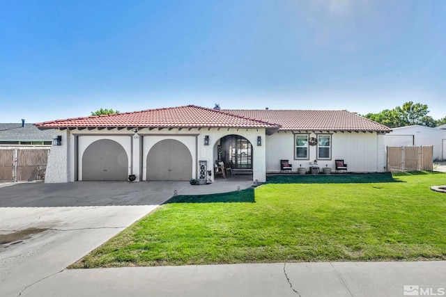 mediterranean / spanish home featuring a front lawn and a garage