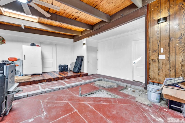 interior space with a ceiling fan, a skylight, beam ceiling, and wooden ceiling