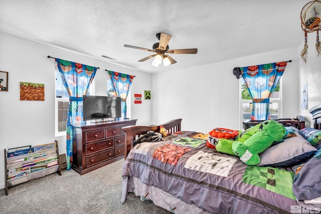 carpeted bedroom with a ceiling fan, visible vents, and a textured ceiling