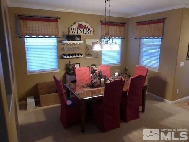 dining space featuring ornamental molding, carpet, and an inviting chandelier