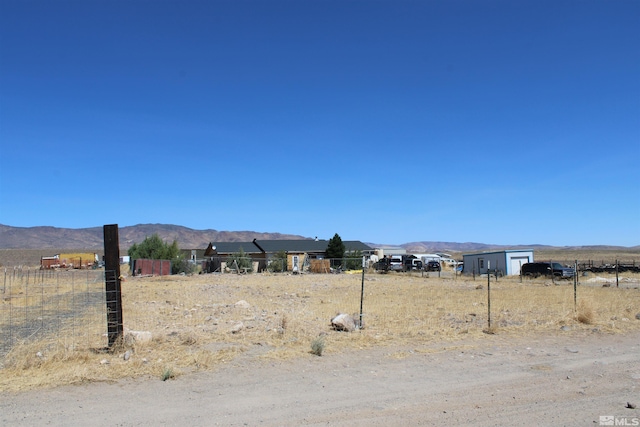 view of yard with a rural view and a mountain view