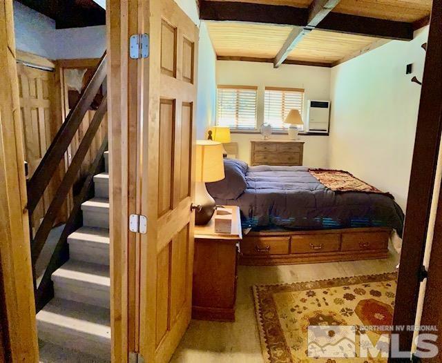 bedroom with beam ceiling, wooden ceiling, and wood finished floors