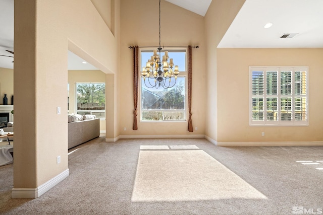 entryway featuring light carpet, ceiling fan with notable chandelier, and high vaulted ceiling