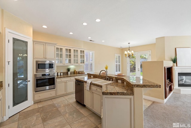 kitchen featuring hanging light fixtures, a chandelier, stainless steel appliances, and a center island with sink