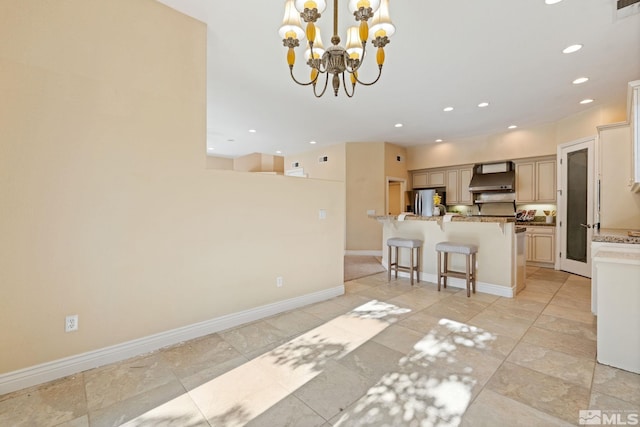 kitchen with custom range hood, decorative light fixtures, light stone countertops, stainless steel fridge with ice dispenser, and a breakfast bar