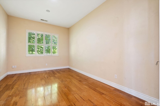 empty room featuring light wood-type flooring and vaulted ceiling