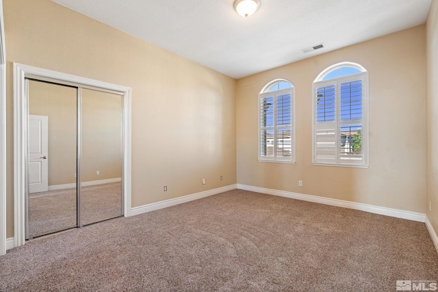 unfurnished bedroom with carpet flooring and a closet