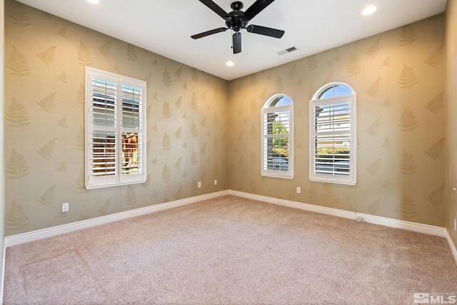 carpeted empty room featuring ceiling fan