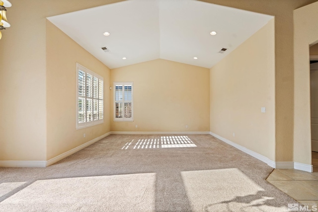 carpeted empty room with vaulted ceiling