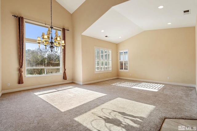 carpeted empty room featuring lofted ceiling and a chandelier