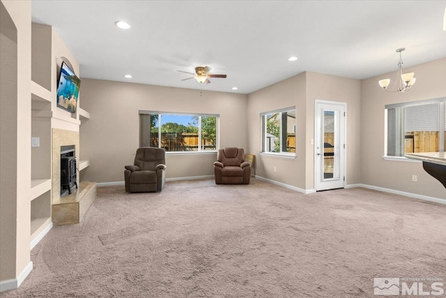 living area with carpet, a fireplace with raised hearth, baseboards, and recessed lighting