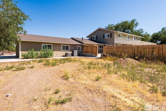 back of house with central AC unit