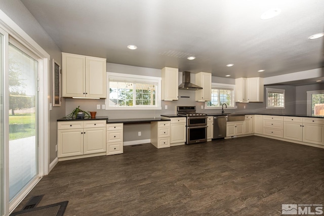 kitchen with dark hardwood / wood-style flooring, appliances with stainless steel finishes, a wealth of natural light, and wall chimney exhaust hood