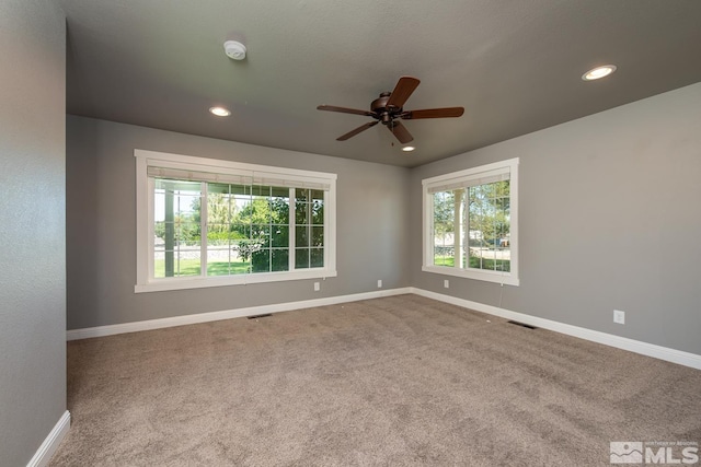 empty room with ceiling fan and carpet floors