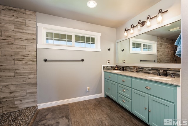 bathroom featuring vanity, a healthy amount of sunlight, hardwood / wood-style flooring, and tasteful backsplash