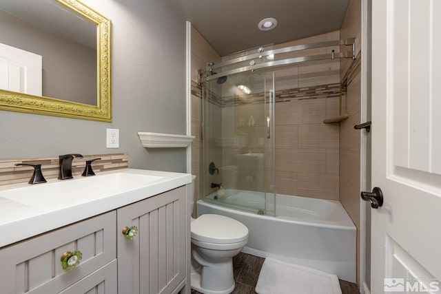 full bathroom featuring shower / bath combination with glass door, vanity, and toilet