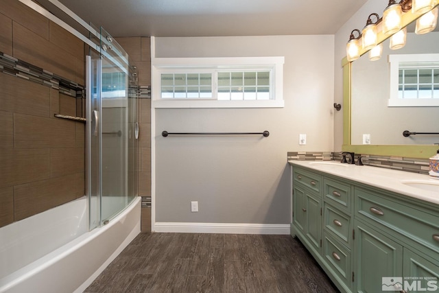 bathroom featuring vanity, a healthy amount of sunlight, hardwood / wood-style floors, and enclosed tub / shower combo