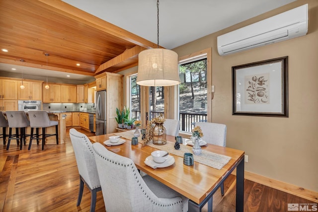 dining space featuring a wall mounted AC and light hardwood / wood-style floors