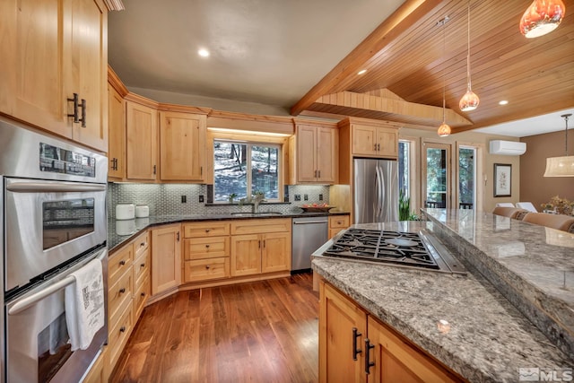 kitchen featuring decorative light fixtures, stone countertops, stainless steel appliances, hardwood / wood-style flooring, and a wall unit AC