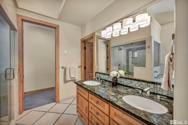 bathroom with tile patterned flooring, vanity, an enclosed shower, and decorative backsplash