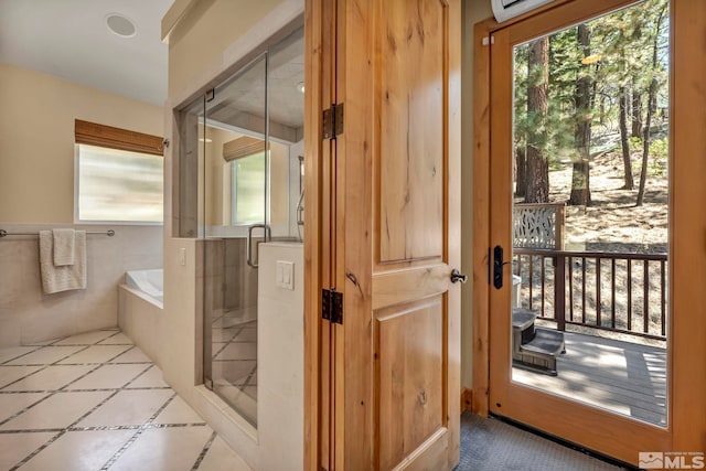 bathroom featuring plus walk in shower, tile patterned flooring, and plenty of natural light