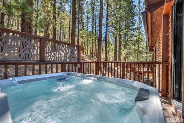 view of swimming pool featuring a hot tub and a wooden deck