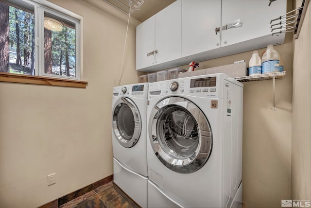 clothes washing area with cabinets and washer and dryer