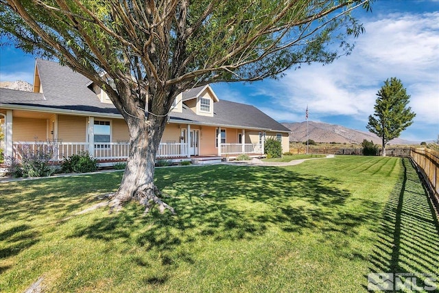 view of front of house with a mountain view, a front lawn, and a porch