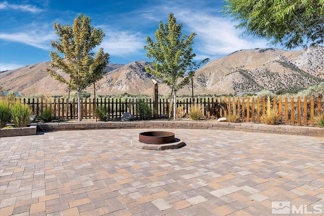 view of patio / terrace with a mountain view and an outdoor fire pit