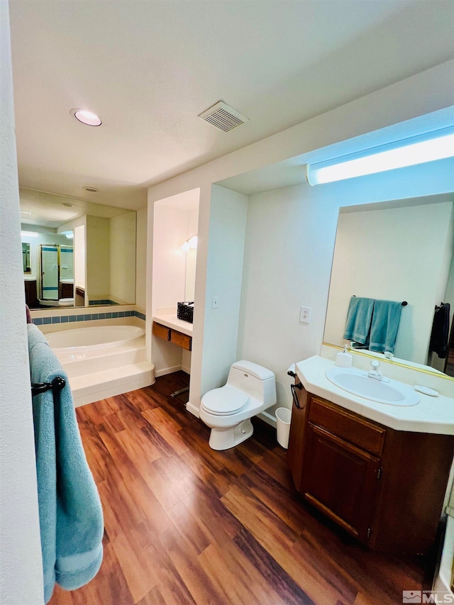 bathroom featuring a tub, wood-type flooring, toilet, and vanity