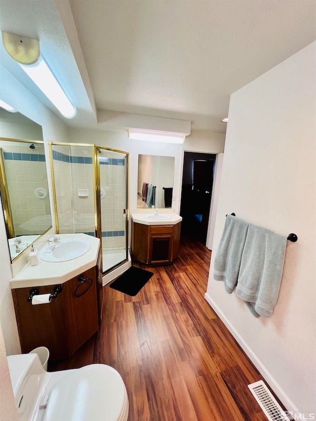 bathroom featuring toilet, an enclosed shower, hardwood / wood-style flooring, and vanity