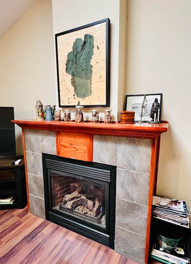 room details featuring a tile fireplace and hardwood / wood-style flooring