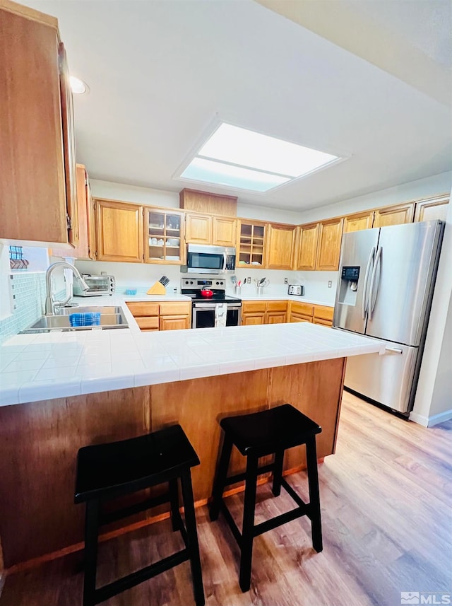 kitchen with a breakfast bar, stainless steel appliances, and kitchen peninsula