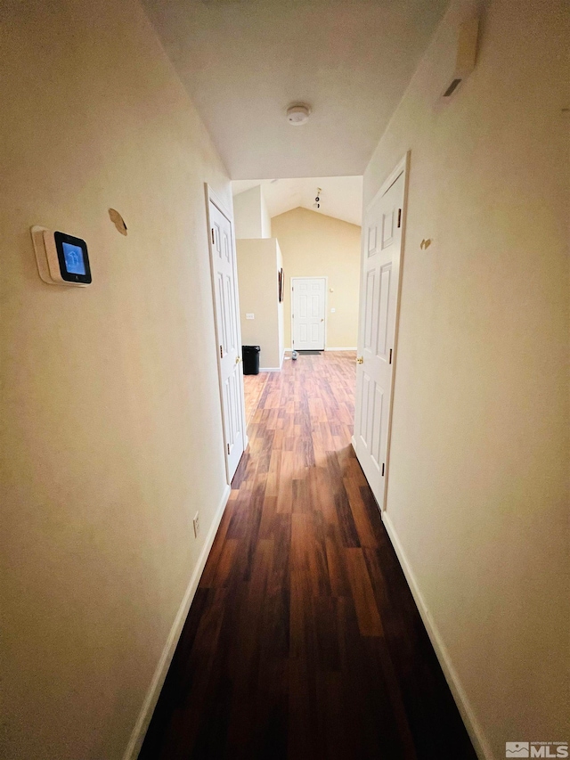 hallway featuring lofted ceiling and hardwood / wood-style flooring