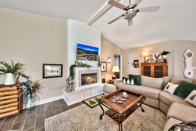 living room featuring dark wood-type flooring, ceiling fan, a fireplace, and vaulted ceiling with beams