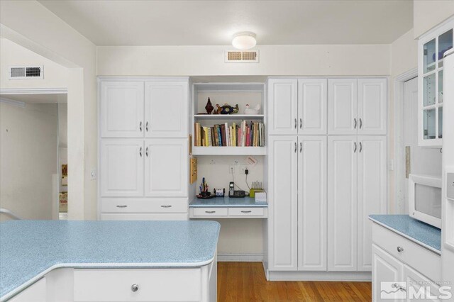 kitchen featuring light wood-type flooring and white cabinets