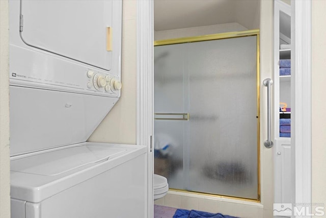 laundry area with stacked washing maching and dryer and tile patterned floors