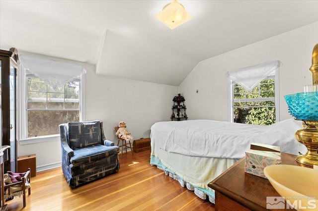 bedroom with vaulted ceiling and light hardwood / wood-style floors