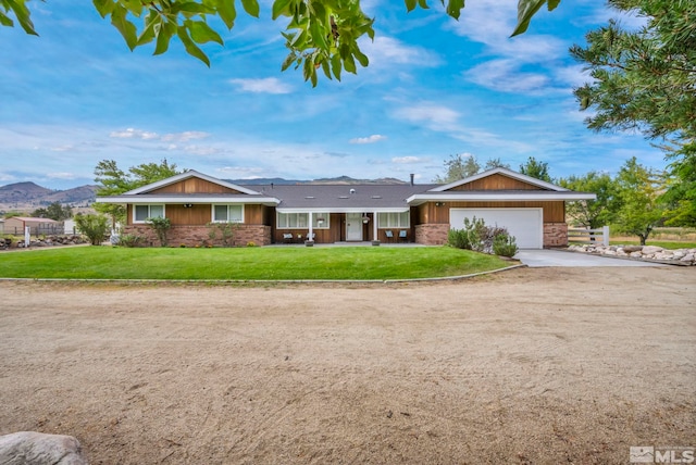 ranch-style home featuring a mountain view, a garage, and a front lawn