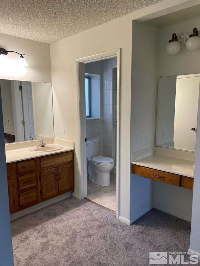 bathroom featuring a textured ceiling, carpet floors, vanity, and toilet